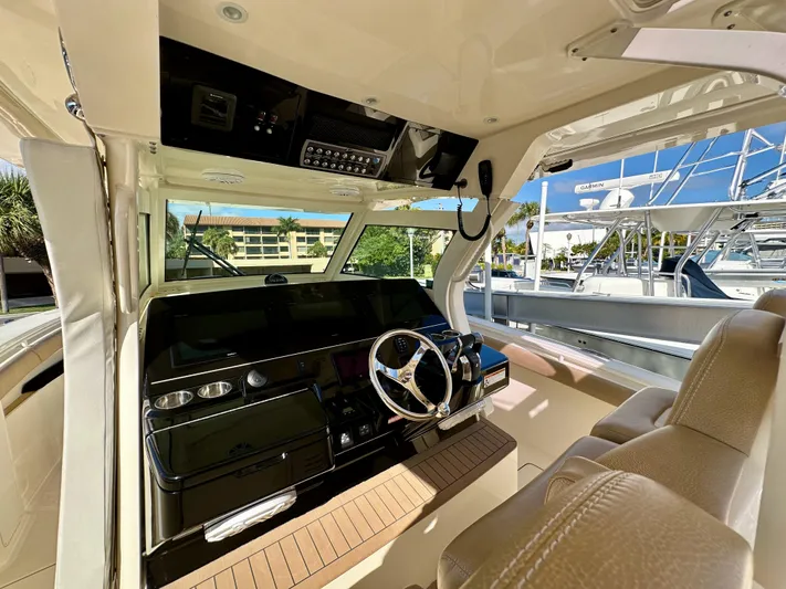  Yacht Photos Pics Interior view of 2019 Scout 380 LXF boat cockpit with steering wheel and controls.