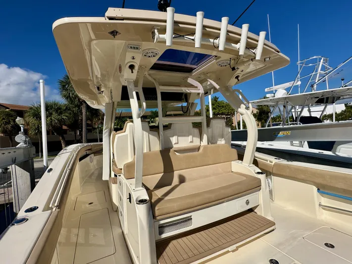  Yacht Photos Pics 2019 Scout 380 LXF boat interior with seating and rod holders, docked under clear blue sky.