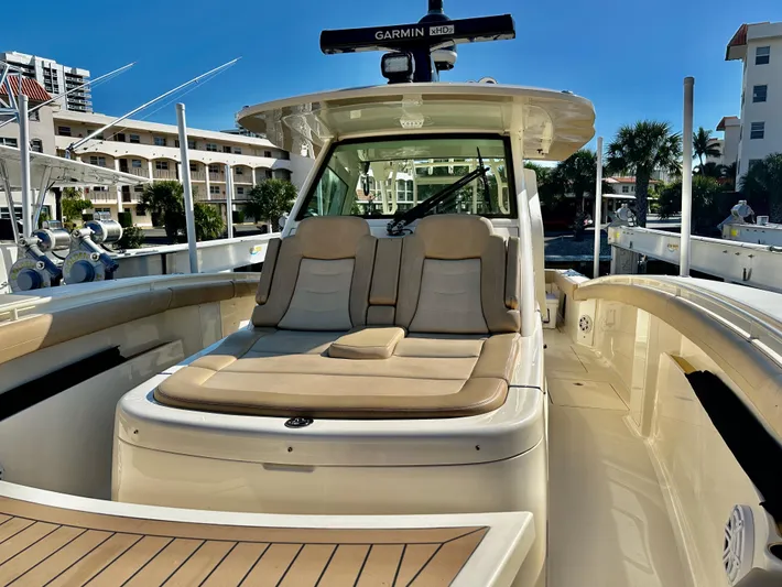  Yacht Photos Pics 2019 Scout 380 LXF boat with cushioned seating and Garmin radar, docked in a marina.
