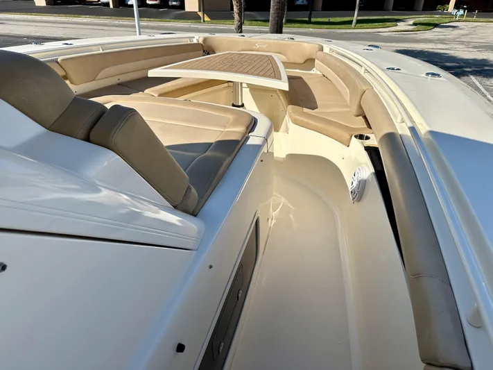  Yacht Photos Pics 2019 Scout 380 LXF boat interior with beige seating and a wooden table.