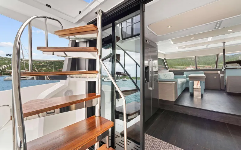 Mona Lisa Yacht Photos Pics Luxurious interior of 2024 Fountaine Pajot MY.6 yacht with spiral staircase and modern design.