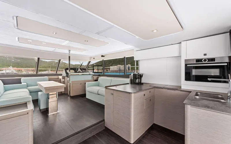 Mona Lisa Yacht Photos Pics Luxurious interior of 2024 Fountaine Pajot MY.6 yacht with modern kitchen and seating area.