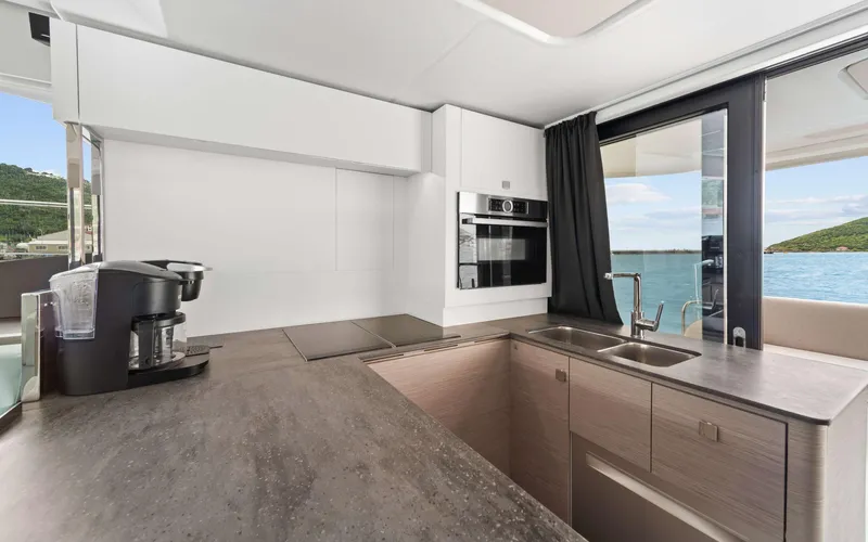 Mona Lisa Yacht Photos Pics Modern kitchen interior on 2024 Fountaine Pajot MY.6 yacht, featuring sleek countertops and ocean view.