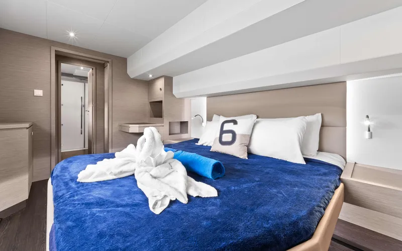 Mona Lisa Yacht Photos Pics Luxurious bedroom interior of 2024 Fountaine Pajot MY.6 yacht with blue bedding.