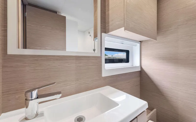 Mona Lisa Yacht Photos Pics Modern bathroom interior of 2024 Fountaine Pajot MY.6 yacht with sleek sink and window.
