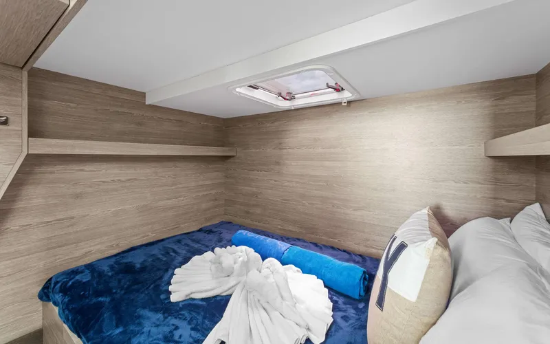 Mona Lisa Yacht Photos Pics 2024 Fountaine Pajot MY.6 cabin interior with cozy bed and modern wood finish.