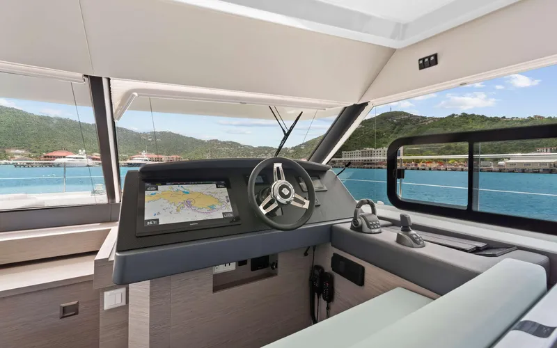 Mona Lisa Yacht Photos Pics 2024 Fountaine Pajot MY.6 yacht helm with navigation display, overlooking scenic coastal view.