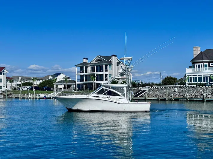 Triple Play Yacht Photos Pics 2005 Carolina Classic 35 boat docked near waterfront homes under clear blue sky.