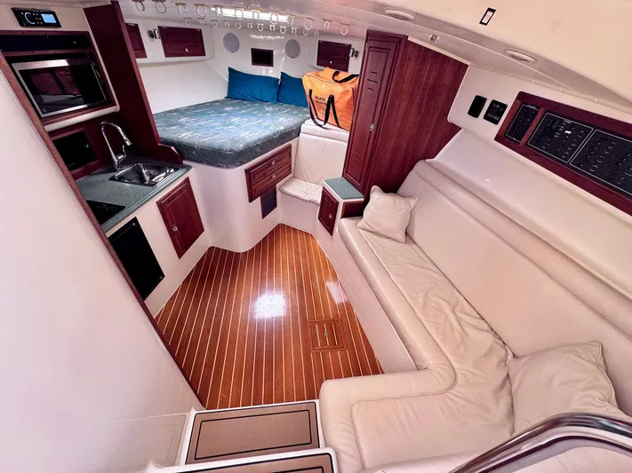 Triple Play Yacht Photos Pics Luxurious interior of a 2005 Carolina Classic 35 boat with wood flooring and cozy seating.