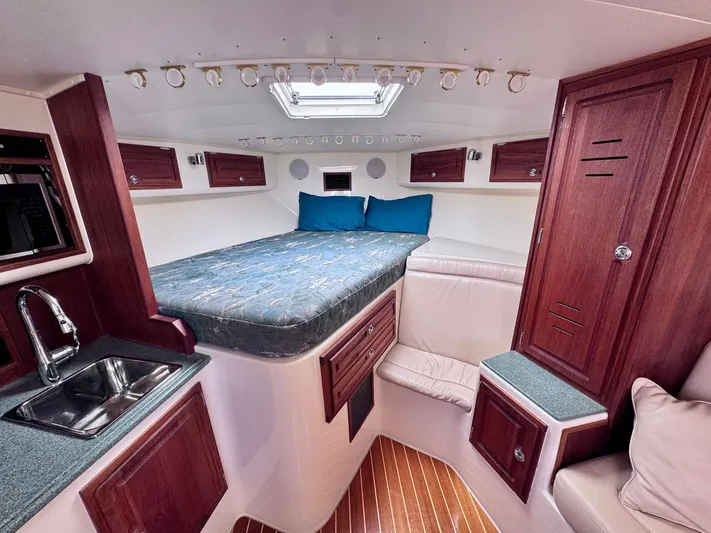 Triple Play Yacht Photos Pics 2005 Carolina Classic 35 cabin interior with bed, sink, and wooden cabinetry.