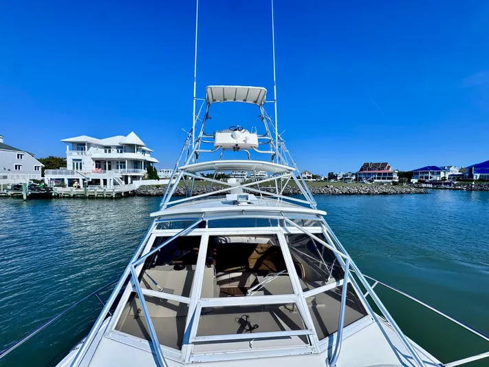 Triple Play Yacht Photos Pics 2005 Carolina Classic 35 boat on water near coastal homes, clear blue sky.