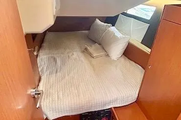  Yacht Photos Pics Cozy cabin interior of 2017 Beneteau Oceanis 41.1 sailboat with bed and wooden furnishings.