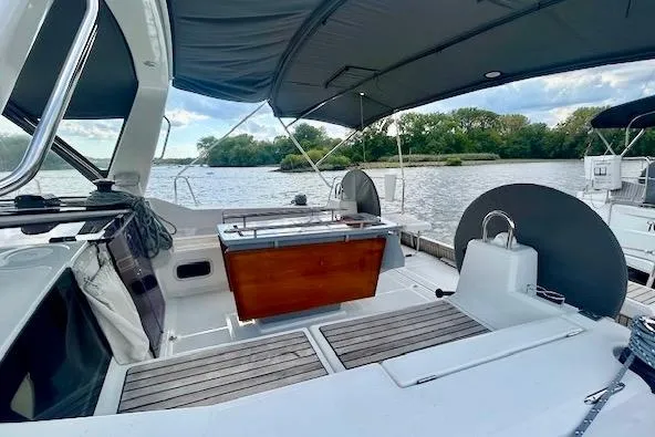  Yacht Photos Pics 2017 Beneteau Oceanis 41.1 sailboat cockpit with canopy, docked by a scenic river.