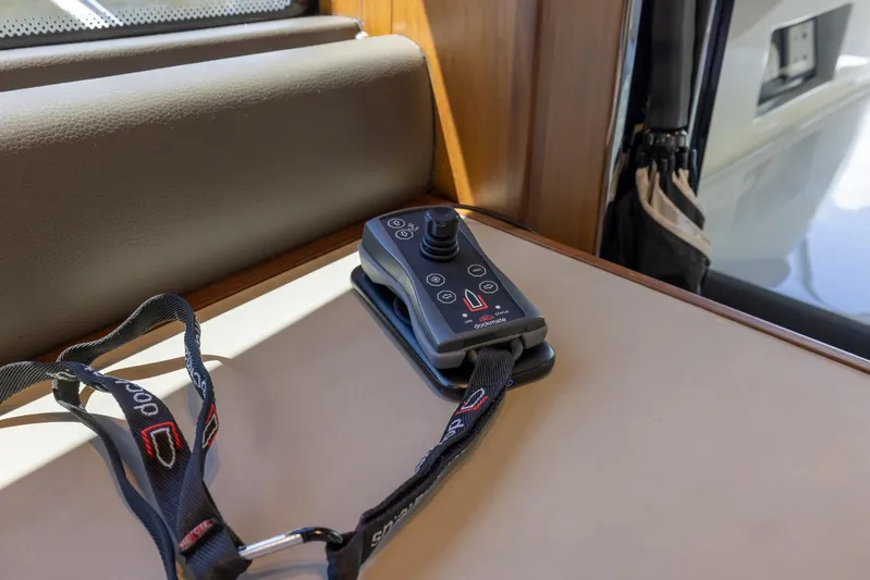 Quick Decision Yacht Photos Pics Remote control on a Princess V50 yacht, 2020 model, placed on a wooden surface.