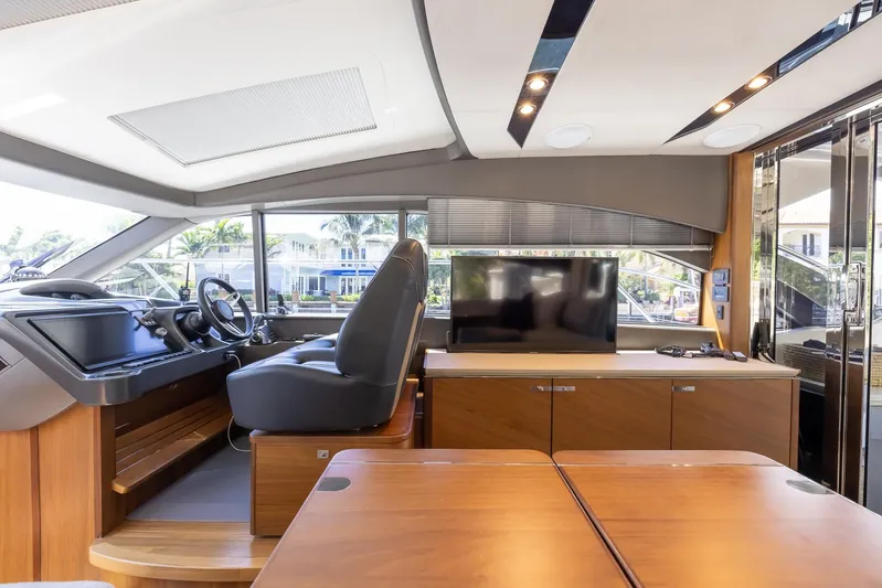 Quick Decision Yacht Photos Pics Interior of 2020 Princess V50 yacht with modern helm, TV, and wooden furnishings.