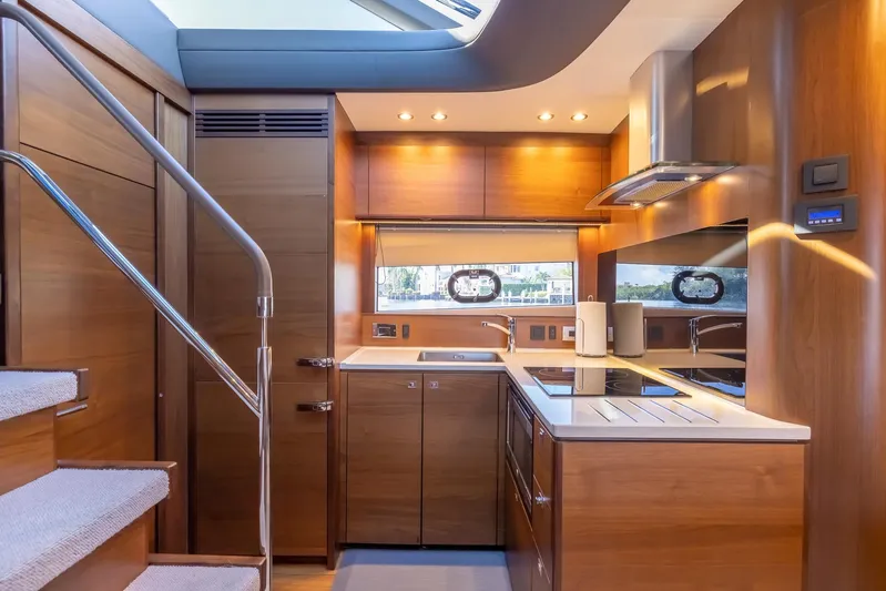 Quick Decision Yacht Photos Pics Modern kitchen interior of 2020 Princess V50 yacht with wooden cabinetry and stainless steel appliances.