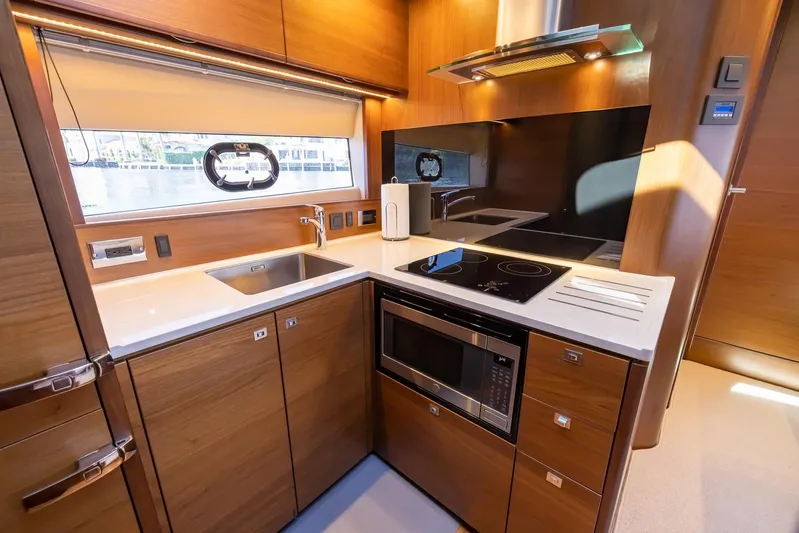 Quick Decision Yacht Photos Pics Modern kitchen in a 2020 Princess V50 yacht with sleek wooden cabinetry.