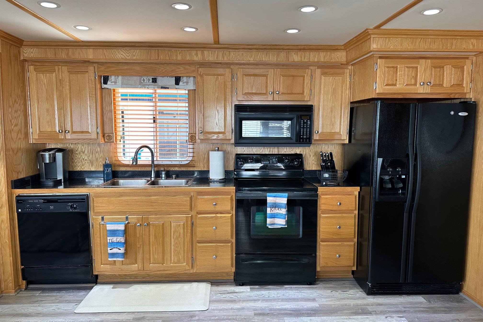 Modern kitchen in 2004 Lakeview 16x68 model with wooden cabinets and black appliances.