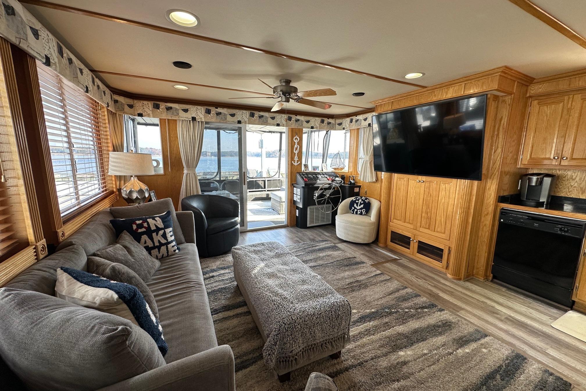 Luxurious 2004 Lakeview 16x68 houseboat interior with cozy living area and large TV.