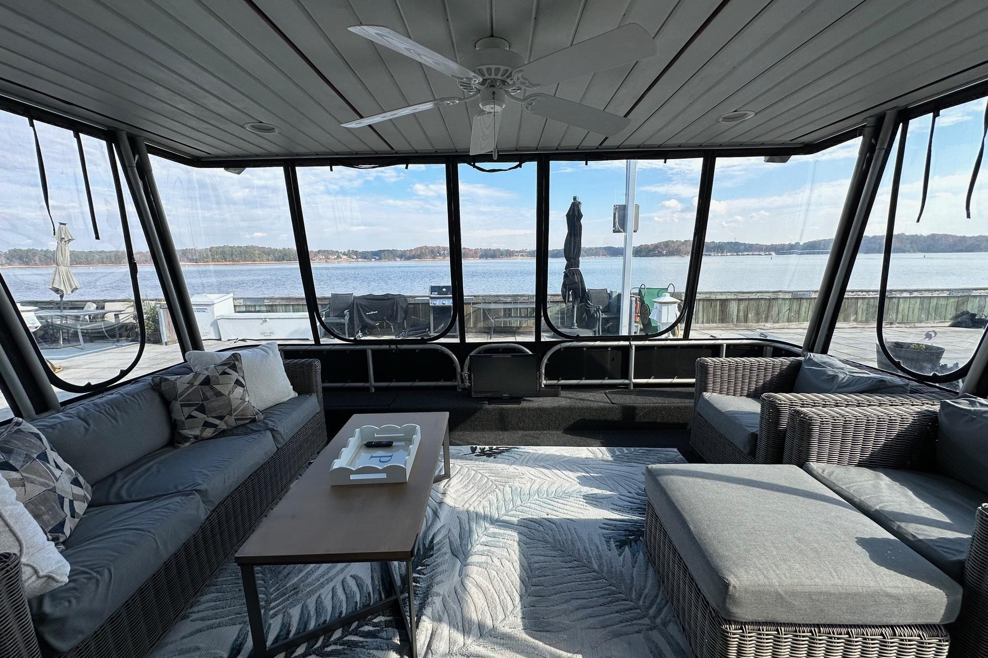 Luxurious 2004 Lakeview 16x68 houseboat interior with lake view, featuring cozy seating and modern decor.