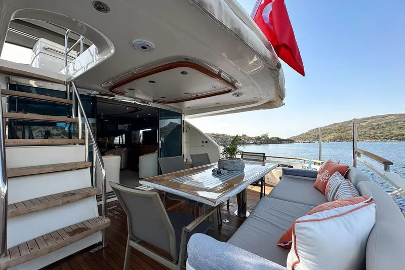  Yacht Photos Pics Luxurious 2004 FAIRLINE SQUADRON 74 yacht deck with seating, table, and scenic water view.