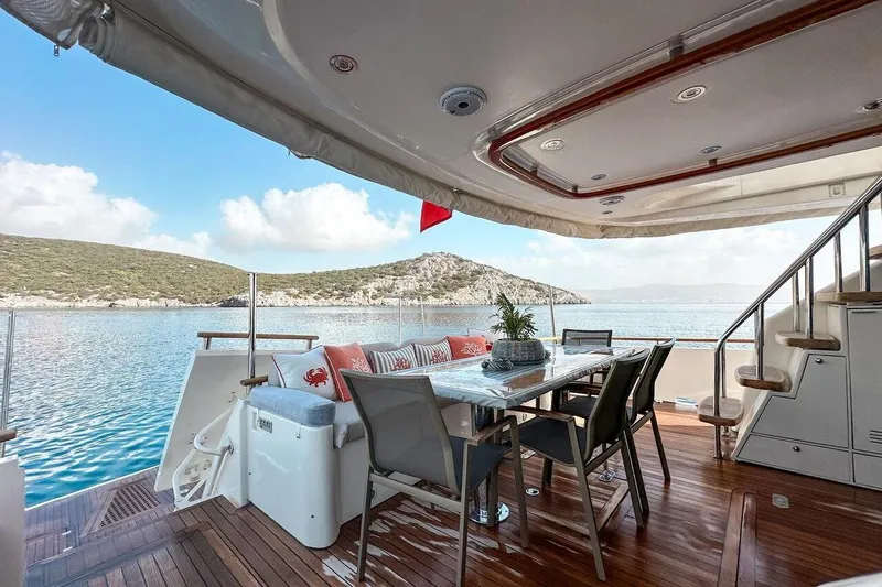  Yacht Photos Pics Luxurious 2004 FAIRLINE SQUADRON 74 yacht deck with dining area, scenic ocean view.