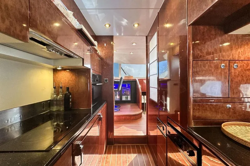  Yacht Photos Pics Luxurious 2004 FAIRLINE SQUADRON 74 yacht interior with elegant wood finishes and modern kitchen amenities.