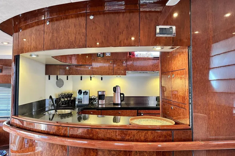  Yacht Photos Pics Luxurious kitchen interior of 2004 FAIRLINE SQUADRON 74 yacht with wood finish and modern appliances.