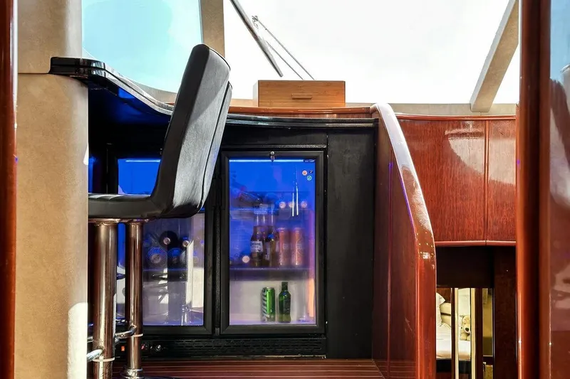  Yacht Photos Pics Luxurious interior of 2004 FAIRLINE SQUADRON 74 yacht with bar and mini fridge.