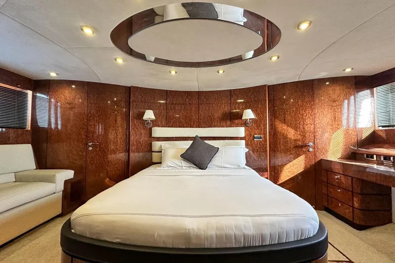  Yacht Photos Pics Luxurious bedroom interior of 2004 FAIRLINE SQUADRON 74 yacht with elegant wood paneling.