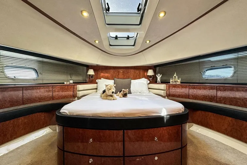  Yacht Photos Pics Luxurious 2004 FAIRLINE SQUADRON 74 yacht bedroom with plush bedding and elegant wood finishes.