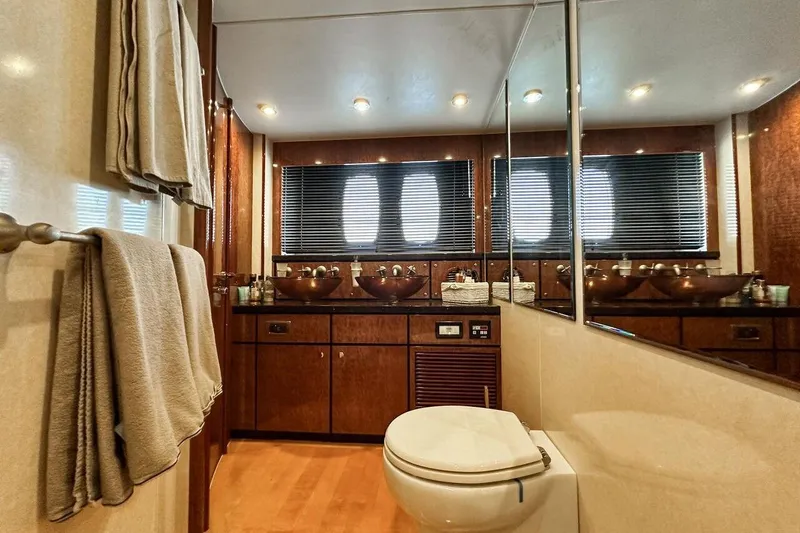  Yacht Photos Pics Luxurious bathroom in 2004 FAIRLINE SQUADRON 74 yacht with elegant fixtures and wooden cabinetry.