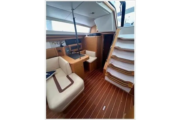  Yacht Photos Pics Interior of 2010 Jeanneau 57 yacht with wooden flooring and comfortable seating.