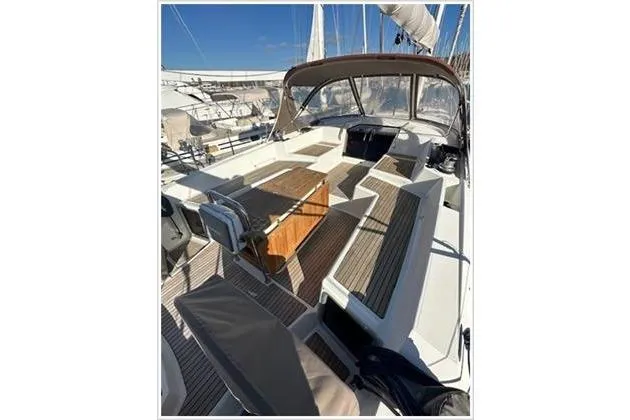  Yacht Photos Pics 2010 Jeanneau 57 sailboat cockpit with teak flooring and seating under a clear blue sky.