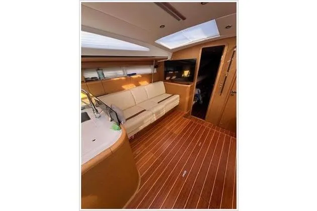 Yacht Photos Pics Interior of 2010 Jeanneau 57 yacht with wooden flooring and modern furnishings.