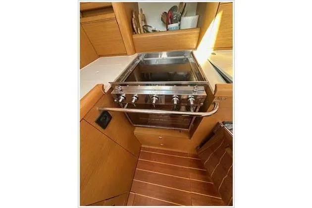  Yacht Photos Pics Galley kitchen in 2010 Jeanneau 57 yacht with stove and wooden cabinetry.