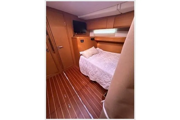  Yacht Photos Pics Luxurious cabin interior of 2010 Jeanneau 57 yacht with cozy bed and wooden flooring.