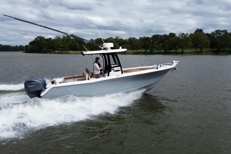  Yacht Photos Pics 2021 Sea Hunt Gamefish 27 Coffin Box cruising on a lake with lush green shoreline.