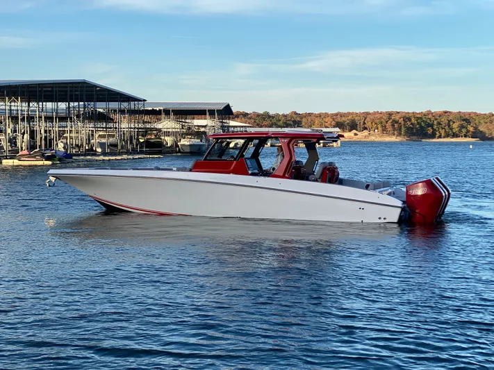  Yacht Photos Pics 2024 Fountain 38 SCX boat on a calm lake near a marina.