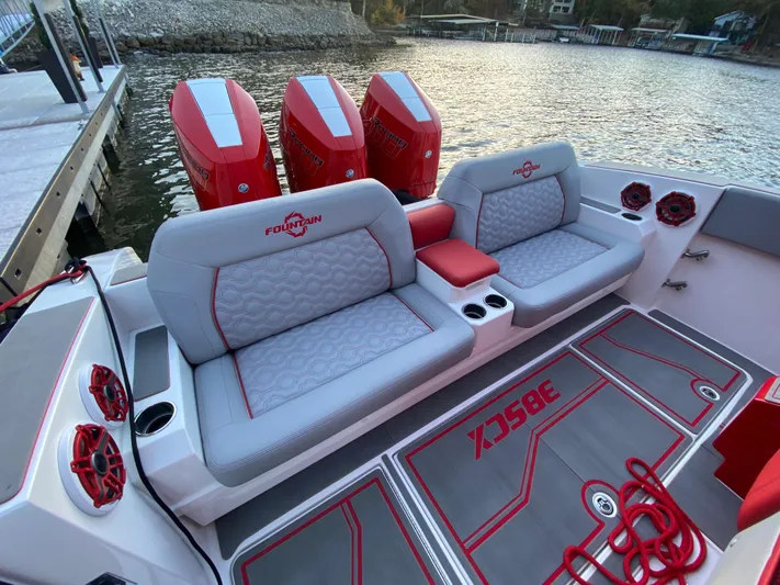  Yacht Photos Pics 2024 Fountain 38 SCX boat interior with red and gray seating, quad engines, and waterfront view.