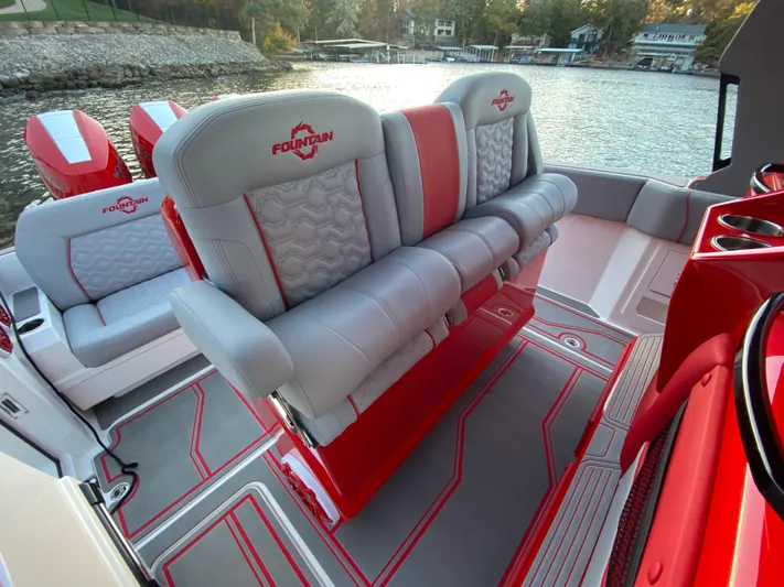  Yacht Photos Pics 2024 Fountain 38 SCX boat interior with red and gray seating by the water.