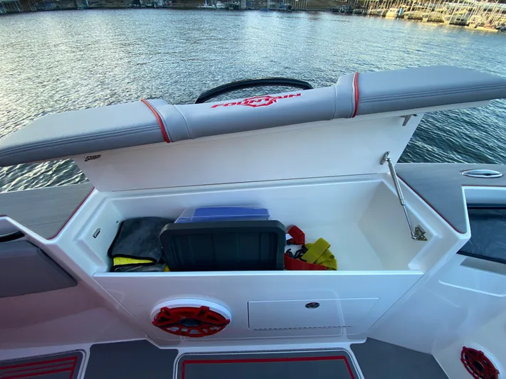  Yacht Photos Pics 2024 Fountain 38 SCX boat storage compartment with open lid, revealing interior items, dockside view.