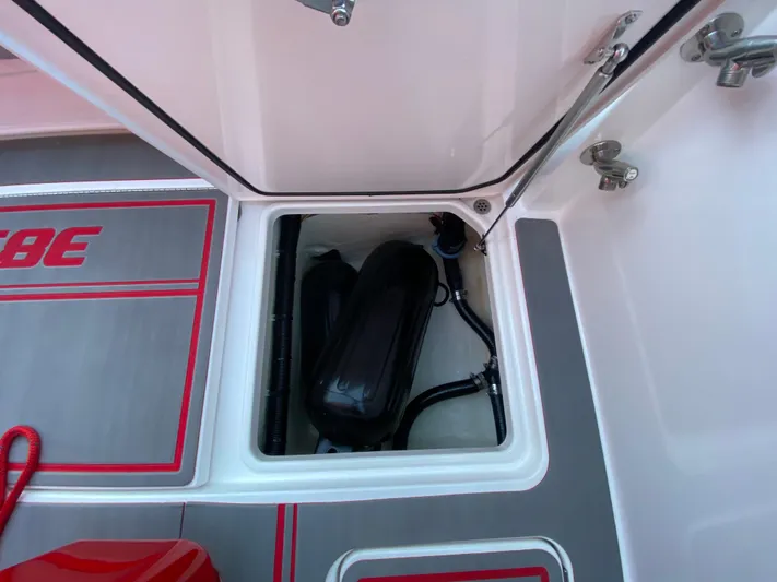  Yacht Photos Pics 2024 Fountain 38 SCX boat storage compartment with equipment and red accents.