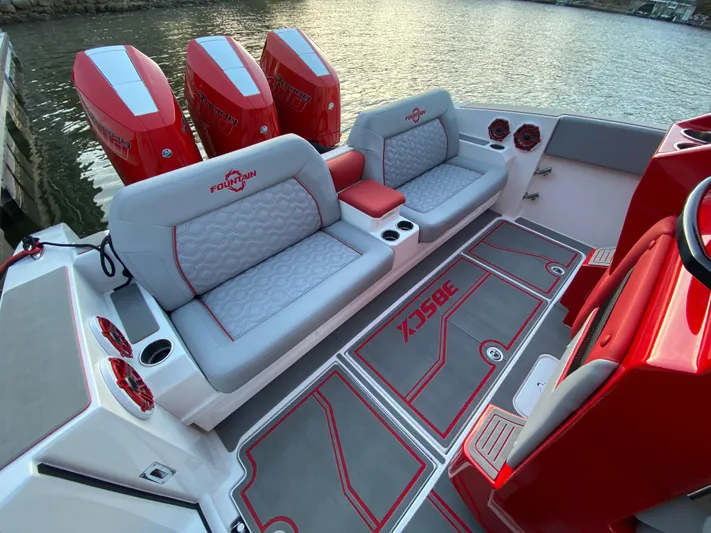  Yacht Photos Pics 2024 Fountain 38 SCX boat interior with red and gray seating, triple engines, and waterfront view.