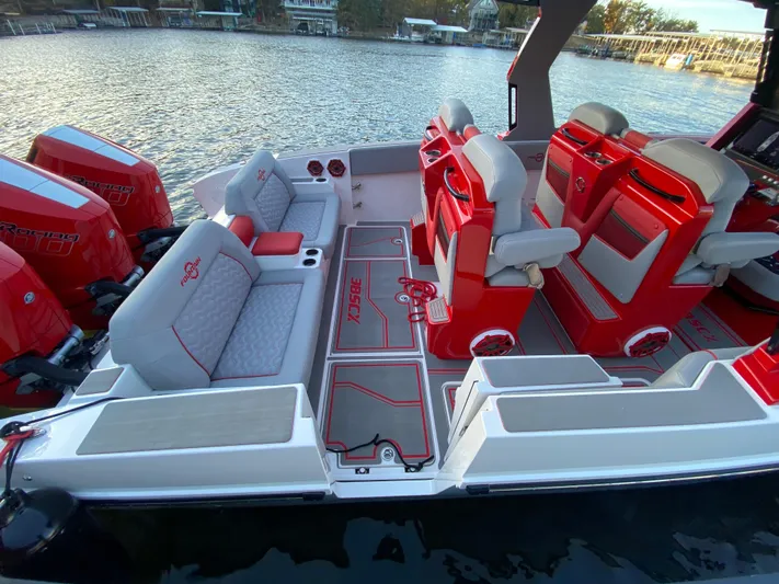  Yacht Photos Pics 2024 Fountain 38 SCX boat interior with red and white seating, docked by the water.