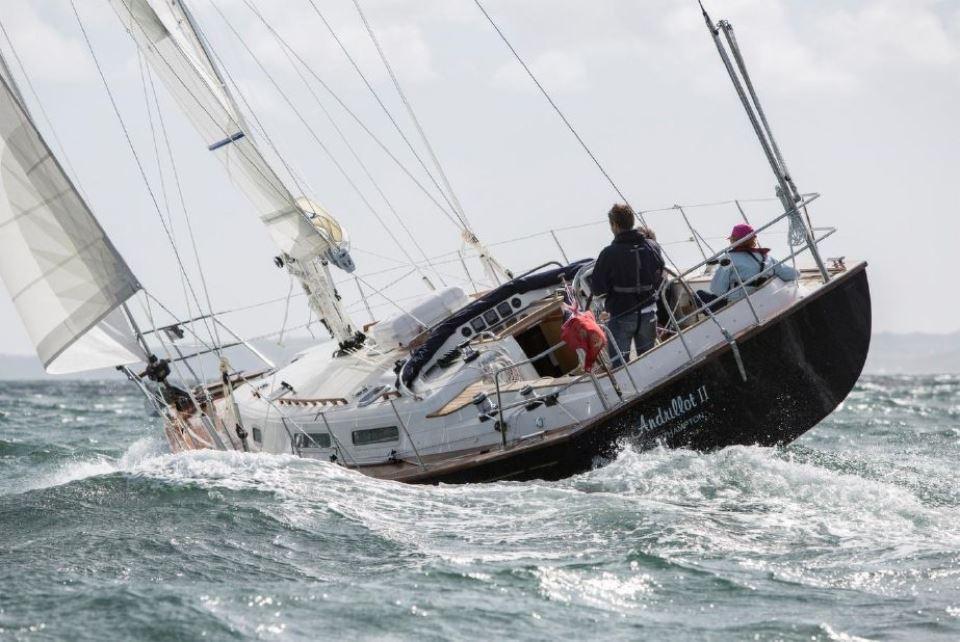 Sailing on a 2025 Rustler 37 yacht in choppy waters, crew navigating skillfully.