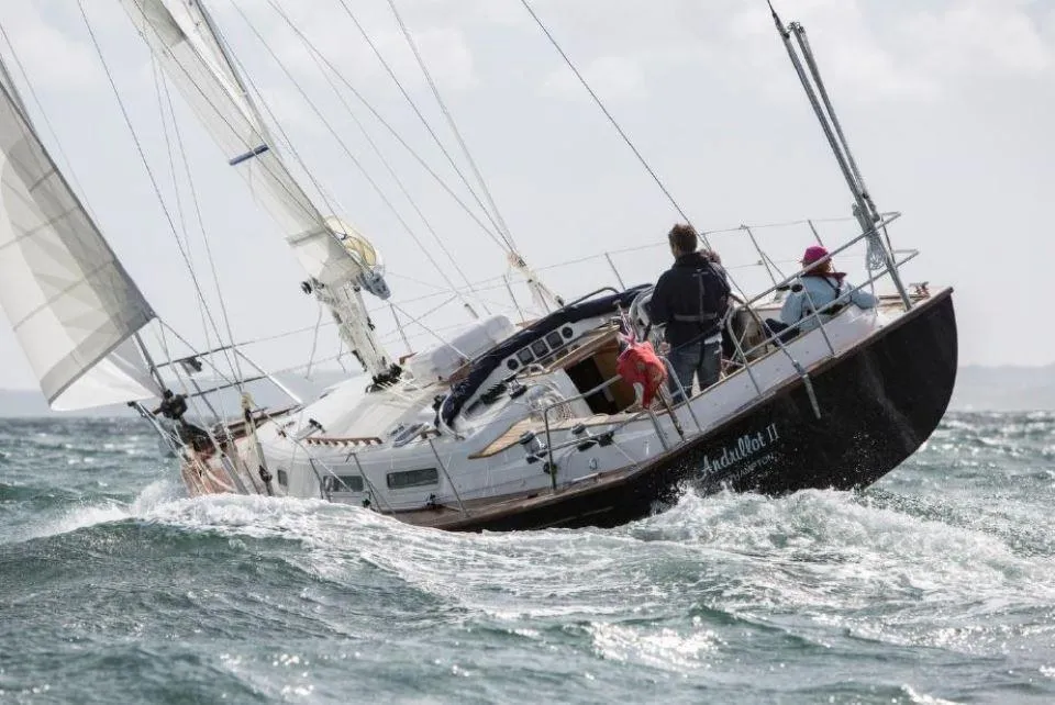 Sailing on a 2025 Rustler 37 yacht in choppy waters, crew navigating skillfully.