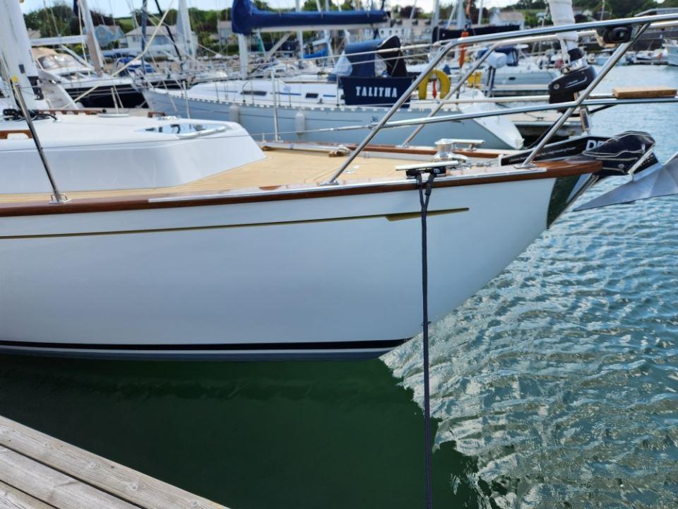 2025 Rustler 37 yacht docked in a marina, featuring sleek design and wooden accents.