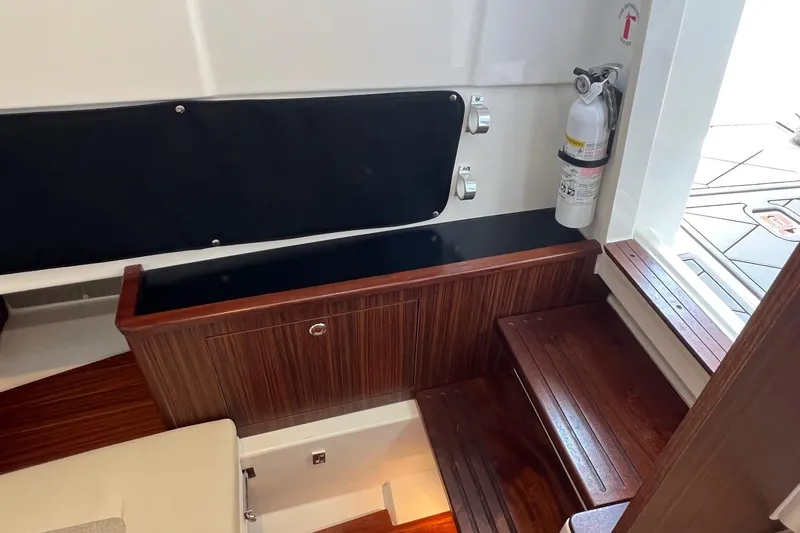  Yacht Photos Pics 2024 Pursuit S 328 Sport interior with wooden steps and safety equipment.