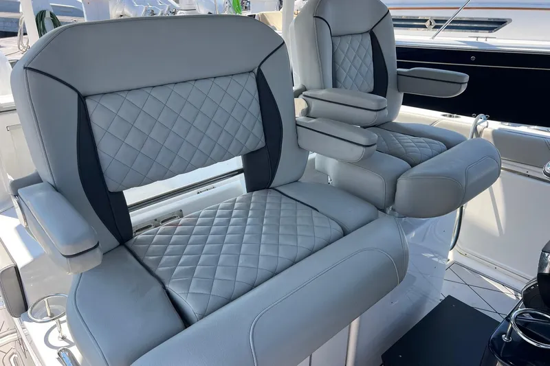  Yacht Photos Pics 2024 Pursuit S 328 Sport boat seats with quilted gray upholstery and armrests.
